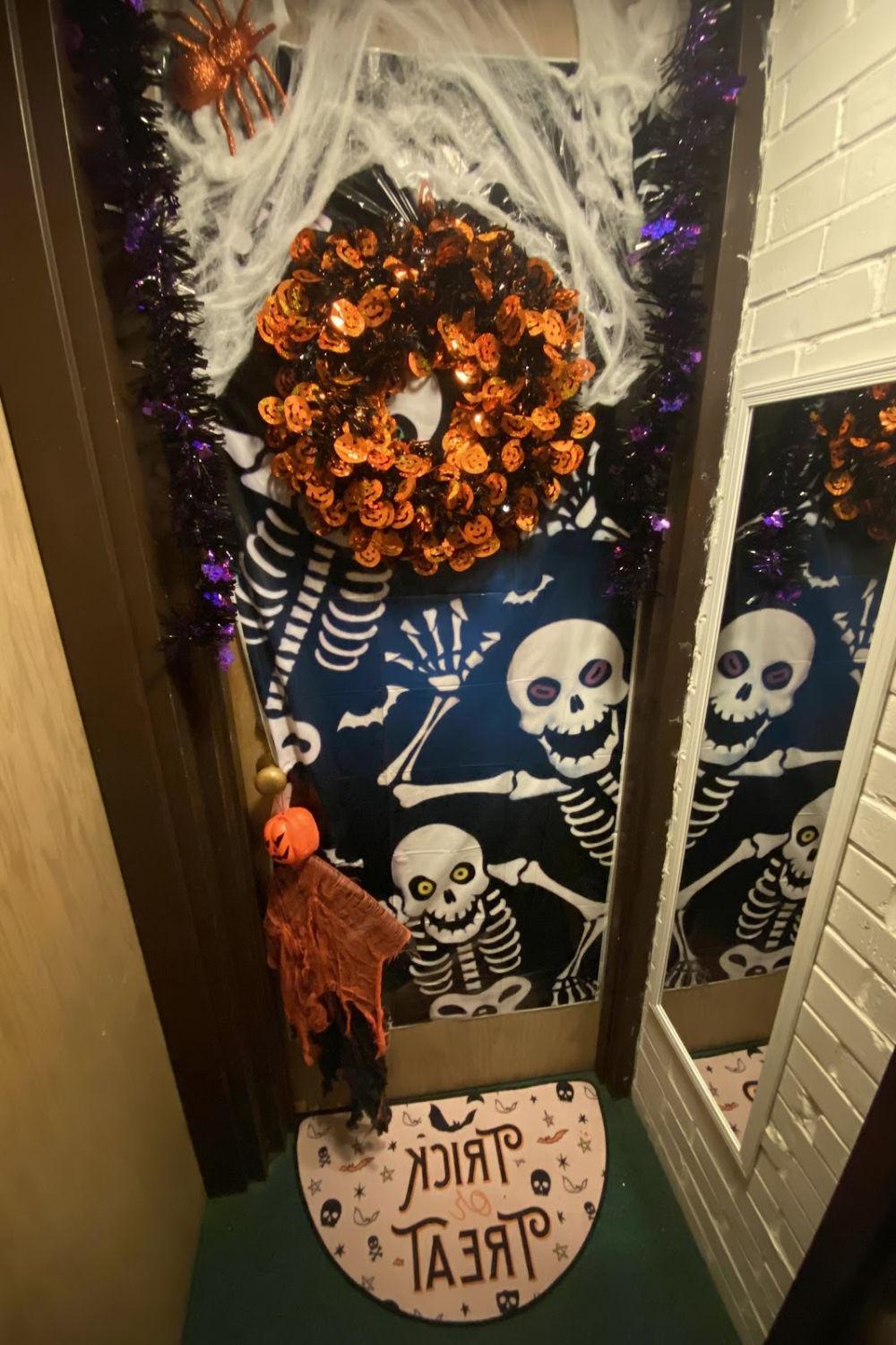 A dorm door with two skeleton friends waving hello.